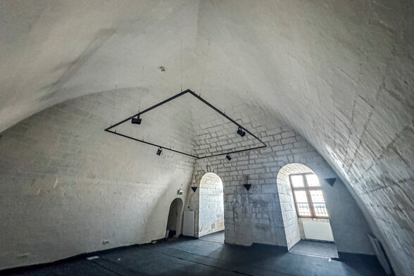 Salle voûtée aux murs de pierre blanche, à l’intérieur du Donjon