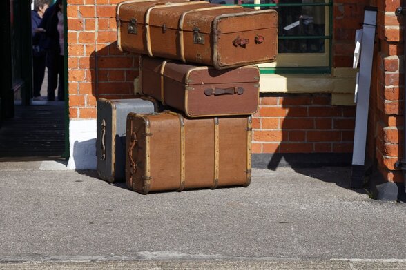Malles et valises anciennes empilées sur un quai de gare