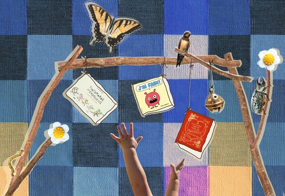 Mains de bébé tendues vers des livres pour enfants suspendus à une arche de branches