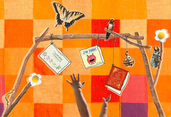 Bras de bébé tendus vers des livres pour enfants suspendus à une arche de branches